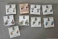 All nine pairs of clip-on earrings laid out on cards