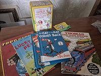 Group shot of assorted books including Dr. Seuss, Thomas activity book, vintage hardcovers and slipcase