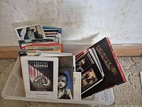 Wide shot of clear plastic bin filled with numerous theatre programs and playbills