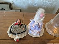 Both dolls, display dome and base on table