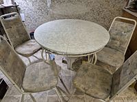 Round laminate table with four metal-frame chairs