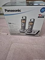 Front of retail box showing model, features, two handsets and base