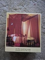 Front of retail box showing red sheer mesh canopy over a bed