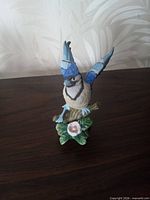 Front view of Lefton porcelain blue jay figurine on floral base