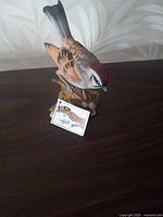 Front view of porcelain sparrow figurine with tag visible