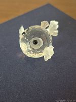 Front angled view of clear faceted crystal puffer fish figurine showing eyes, fins and mouth