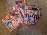 Nine Time magazines spread on carpet showing various 1980s–1990s covers
