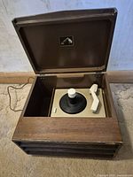 Closed wooden cabinet record player showing exterior and power cord