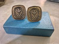 Front view of both cufflinks displaying maple leaf and Olympic rings emblem