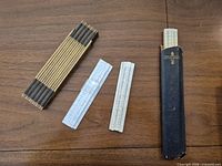 Folded carpenter rule, two pocket slide rules, long slide rule in sleeve