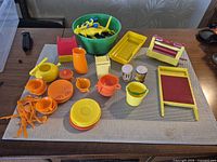 Mixed toy kitchenware, utensils, washboards, bucket, crate and bowl of animals displayed