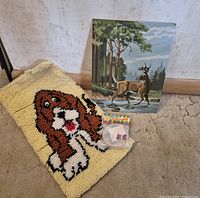 Group shot of latch hook rug, paint-by-number painting, and sealed embroidery kit