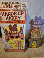 Front of original box beside full cowboy backboard