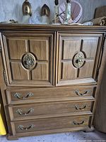 Front view showing paneled cabinet doors and three lower drawers