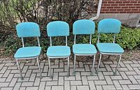 front view of four turquoise vinyl dining chairs on chrome frames