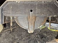 Back underside of cast iron sink showing mounting hole and rust