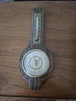 Front view showing full wood plaque, thermometer and barometer