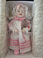 Doll in protective wrap inside presentation box showing outfit and accessories