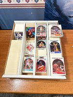 Open four-row storage box filled with sorted trading cards
