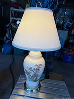 Full view of lit ceramic table lamp with shade