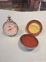 Stopwatch next to open hinged protective case