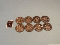 Group of eight Canada 50-cent coins displayed obverse side up next to postage stamp for scale