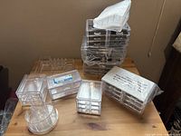 Group of acrylic organizers on table, showing variety of shapes and drawer counts