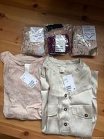 All five items laid out: two tops with tags, sealed 3-pack panties