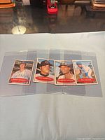 All four Topps baseball cards in sleeves