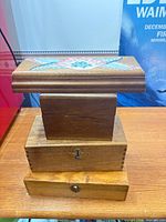 Stack of four wooden boxes showing variety of finishes and painted lid