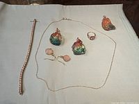 Overview of all seven jewelry pieces on cloth background