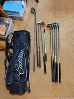 Full view of Cadillac stand bag with nine MacGregor clubs laid out