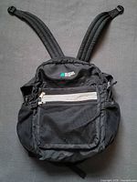 Front view of MEC black nylon daypack showing overall design, pockets, straps