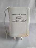 Front cover of pocket New World Translation Bible showing grey leatherette, title and discoloration