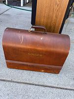 Closed wooden Singer case showing exterior condition and handle