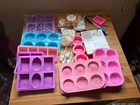 Overview of kit showing all silicone molds, soap bases, loofah pads, spray bottles, cutter and instructions