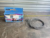 boxed dummy CCTV camera housing and coiled grey cable