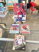 Group shot of all four Alex Ovechkin cards including oversized card on stand and three standard-size cards