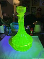 Front view of uranium glass decanter glowing under UV light