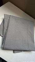 Folded stack of black and white gingham fabric on table