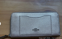 Front view showing exterior slip pocket and Coach logo