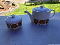 Teapot and sugar bowl front showing floral band