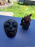 Overall view of wooden mask and Buddha figurine