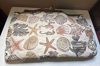 Folded length of sea life jacquard fabric showing full pattern and fringe