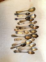 Front view of 18 assorted silver-plated spoons laid out