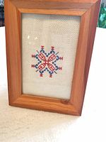 Front view showing framed cross-stitch piece