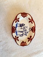 top view showing hand-painted blue scene and red-brown border