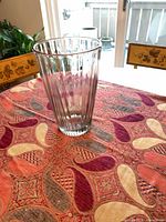 Full view of tall clear ribbed glass vase on table
