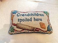 Front of pillow showing full needlepoint design and text