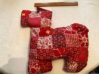 Front view of red patchwork cotton cushion with ruler for scale